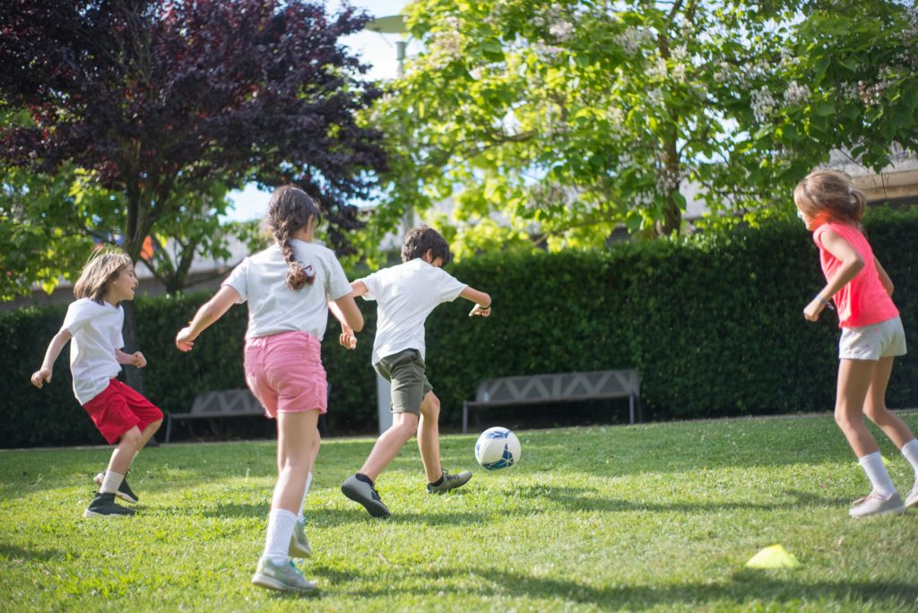 kids playing soccer on turf